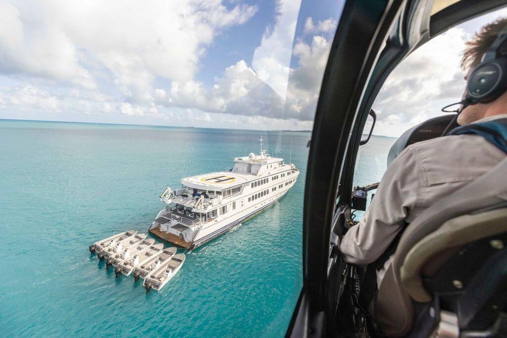 Aerial view from helicopter of True North cruise ship with tenders