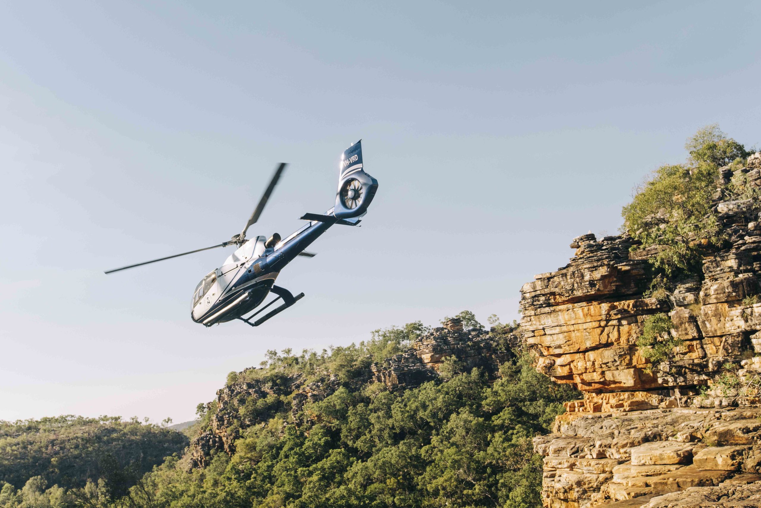 Helicopter flying over a remote Kimberley billabong on a luxury True North cruise for couples