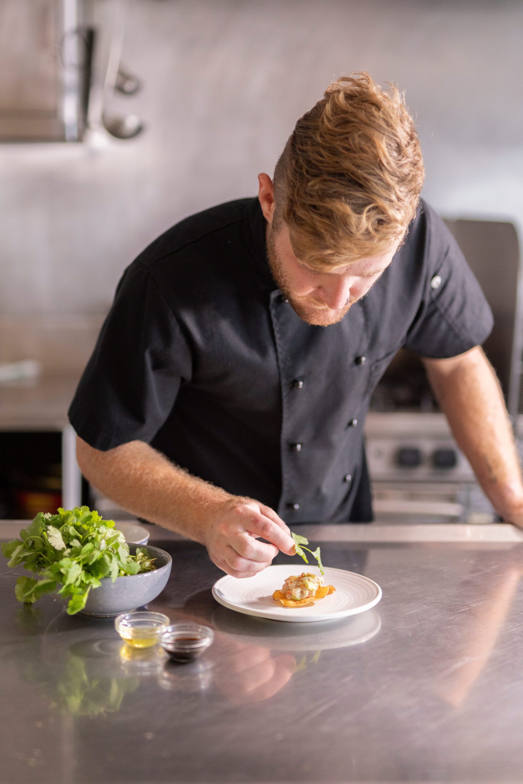 Preparing a gourmet dish with fresh local ingredients aboard TRUE NORTH
