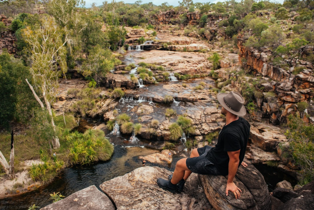 Tourist enjoys lush Kimberley falls - True North Adventure Cruise